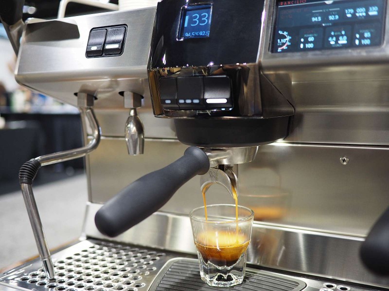 This image is a closeup view of the Rancilio Specialty RS1 espresso machine in Stainless Steel, with adjustable drip tray for varied brew group height and volumetric dosing controls.
